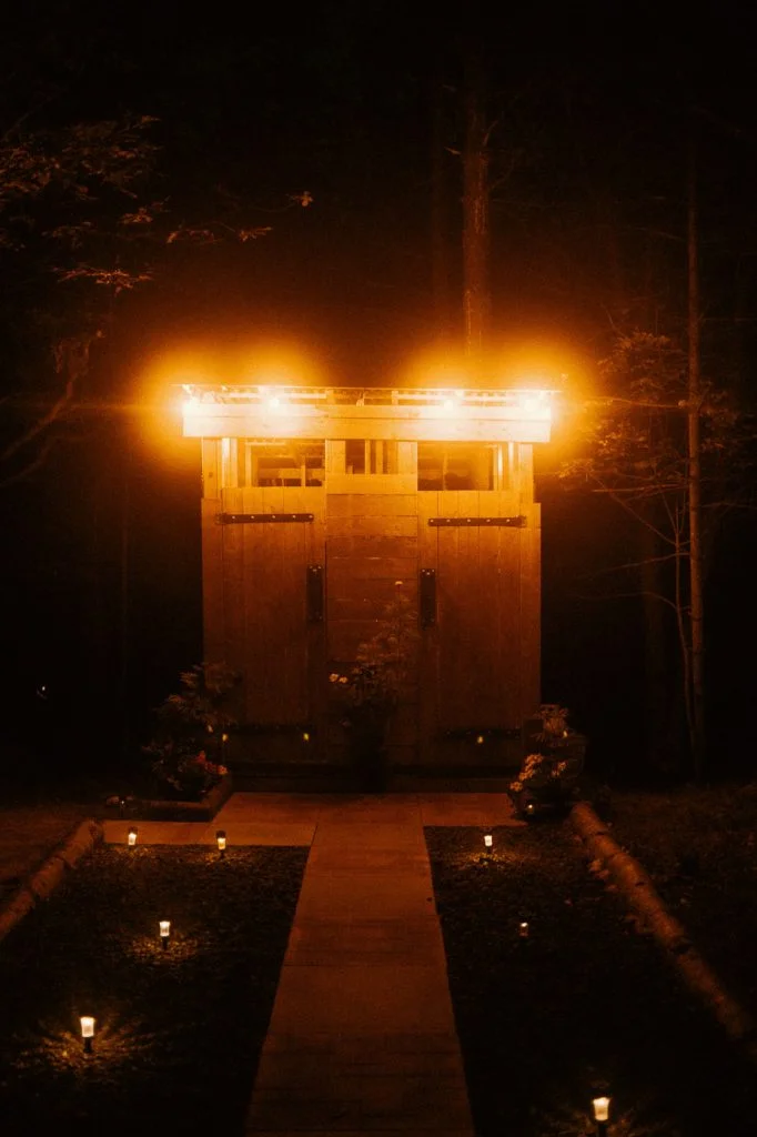 Shower and Toilet Cabin Lit Up at night on Sibo's Bell Tent Glamping Site in Verona, Ontario
