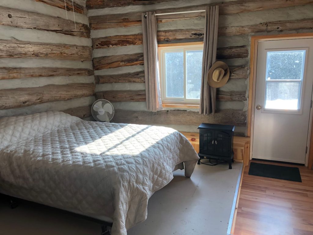 Humble Ranch - Bedroom and Fireplace inside Log Cabin
