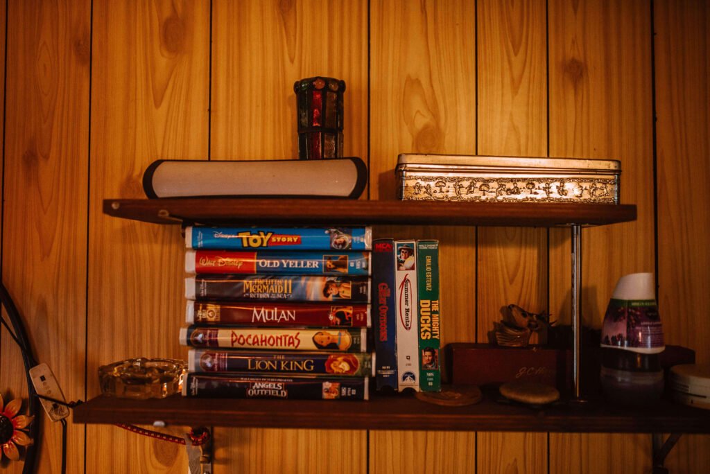 Floating shelf with 90s nostalgia movies including video cassettes of Disney movies and other family favourites