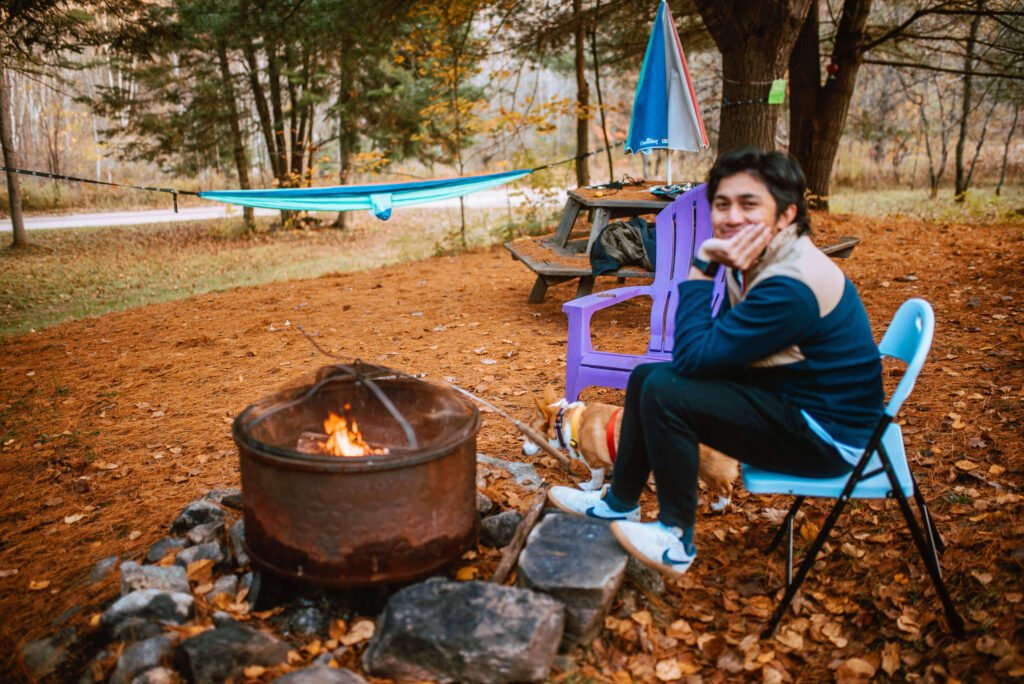 Angelo from SYDE Road taking a break by the firepit at the rustic cozy cabin near Minden, Ontario - a Hipcamp Canada listing