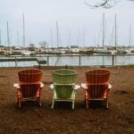 2 Red and 1 Green Muskoka Chair in Coronation Dog Park facing the Marina and Yacht Club on Lake Ontario